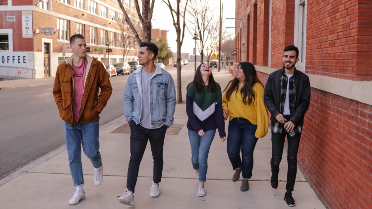 young adults walking and laughing together on a downtown street