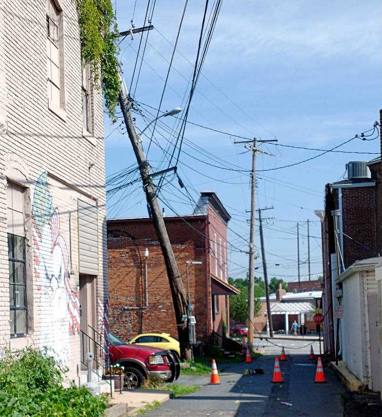 telephone pole cracked and leaning with dozens of various wires attached - following a fast and furious storm in Havre de Grace